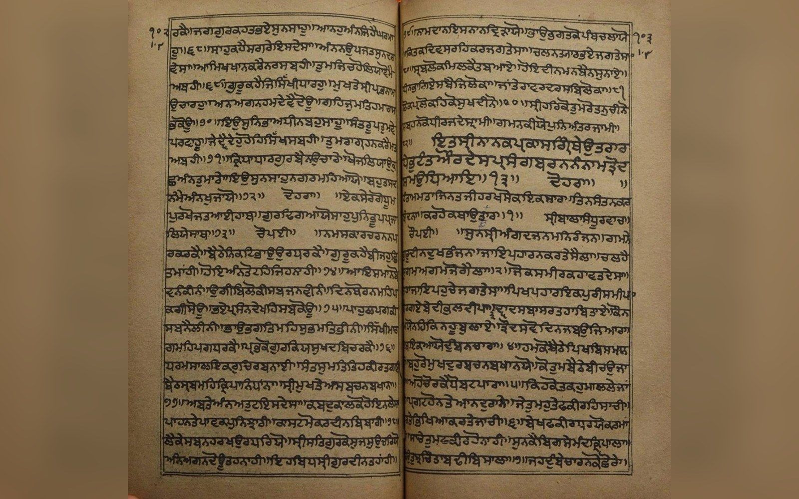 An open book showing two facing pages of Gurmukhi script written without spaces between words